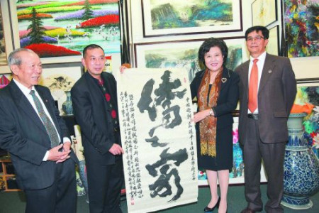 “樂雅齋”主人、華人書畫家鄧作列給裘援平送了“僑之家”書法作品。(毛建軍 攝)