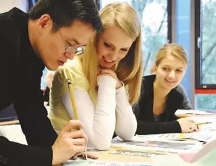 圖為一名老師在指導(dǎo)外國學(xué)生學(xué)寫毛筆字。