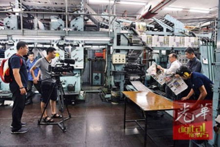 （左起）邱智堅(jiān)、林星發(fā)及李興前觀察剛出爐的報(bào)紙。（馬來(lái)西亞《光華日?qǐng)?bào)》）