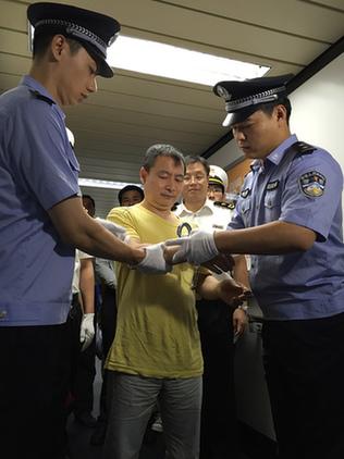 嫌疑人黃某被戴上手銬。蔡巖紅攝