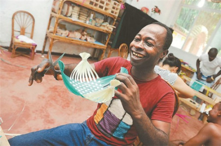 親手完成了第一件竹編制品“十字形小果盤”，學(xué)員明塔笑逐顏開。