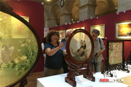 來自法國巴黎的Joelle Durieux女士對湘繡十分感興趣，特別是雙面全異繡《熊貓·老虎》，圖為她正用手機拍下《熊貓·老虎》。