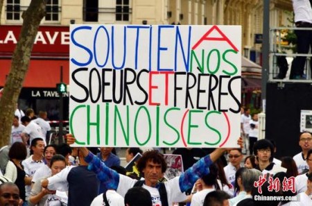 圖為一名非亞裔人士在游行現場打出支持華人的標語。 <a target='_blank' >中新社</a>記者 龍劍武 攝