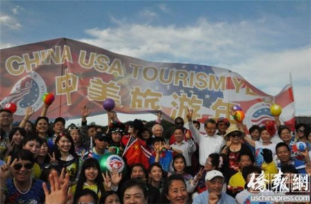 快閃活動(dòng)參加者在“中美旅游年”橫幅前合影留念。(《僑報(bào)》記者徐一凡攝)