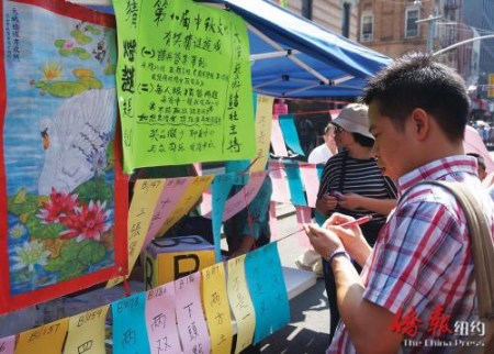 民眾現(xiàn)場參加中秋猜燈謎游戲。(美國《僑報》/陳辰 攝) 