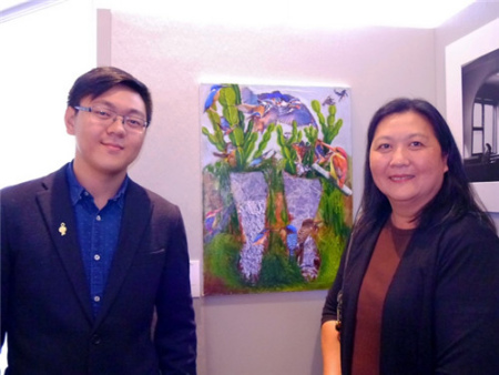 紐約視覺藝術(shù)學(xué)院大一生黎士軒(左)及母親，在其作品《我站在何處》旁合影。(美國《世界日報》/胡毓玲 攝)