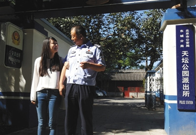 9月19日上午，天壇公園派出所門口，菲菲挽著民警侯祥煒的胳膊。22年前，侯祥煒接群眾報(bào)警，從公園南門東側(cè)的一棵柏樹(shù)下，將被遺棄的菲菲抱回。(圖片來(lái)源：新京報(bào))