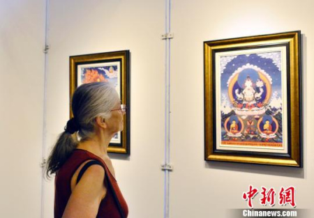 圖為文化周開幕式上法國觀眾欣賞唐卡藝術(shù)展品?！↓垊ξ?攝