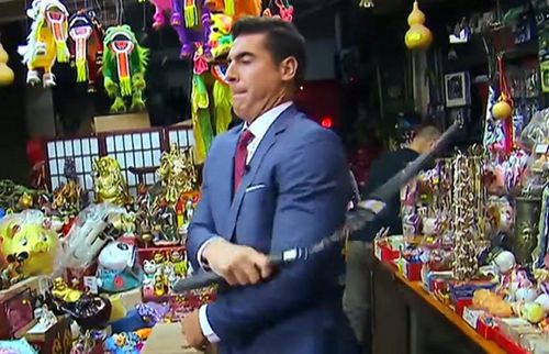 沃特斯在節(jié)目中耍弄雙截棍。（美國(guó)中文網(wǎng) ?？怂剐侣劷貓D）