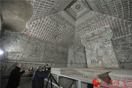 攝影師在61窟內(nèi)進(jìn)行創(chuàng)作。(郭頌霞 攝)