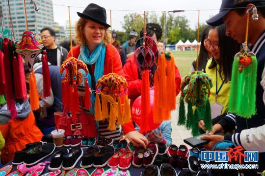 外國(guó)游客購(gòu)買手工布鞋。　冉文娟 攝