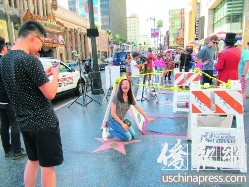 一對情侶在留影拍照時(shí)并不知道這是特朗普之星被破壞現(xiàn)場。(美國《僑報(bào)》/翁羽 攝)