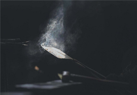 淬火后冒著青煙的刀坯，呈現(xiàn)出手工鍛造的靈魂。