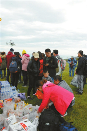 受困游客領(lǐng)取總領(lǐng)事館空運來的食品和瓶裝水。