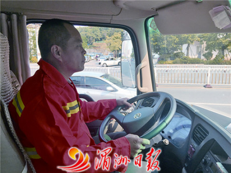 圖為灑水車司機張國慶在馬路上灑水作業(yè)。