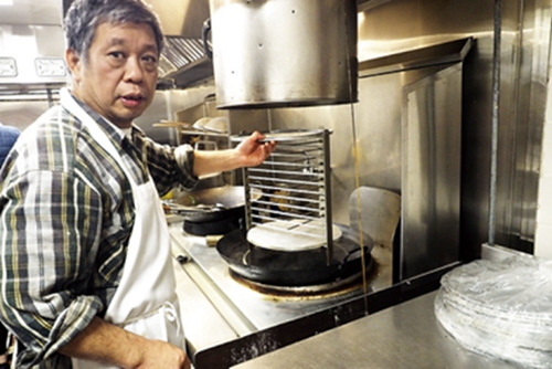 三和主廚何繼彤展示蒸粉廚具。(美國《世界日報》/關(guān)文杰 攝)