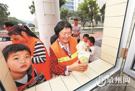 領(lǐng)到饅頭和豆?jié){，環(huán)衛(wèi)工人笑開懷。(戴涵琦 攝)