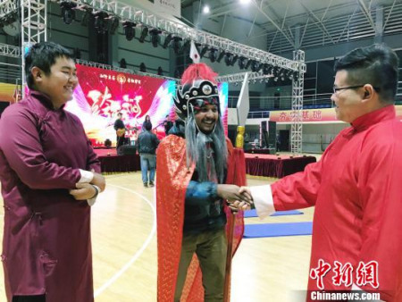 裝扮成中國古代將軍的留學(xué)生伊姆與準(zhǔn)備說相聲中國大學(xué)生交流。(楊云 攝)