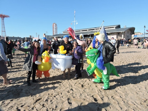 參加北極熊冬泳的泳客，帶著各式道具在水中“戲水”。(美國《世界日報》/許振輝 攝)