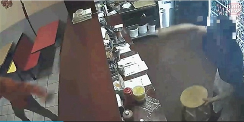 看到一名工人抄起凳子準(zhǔn)備砸過去，歹徒轉(zhuǎn)身逃跑。(美國中文網(wǎng)/視頻截圖)