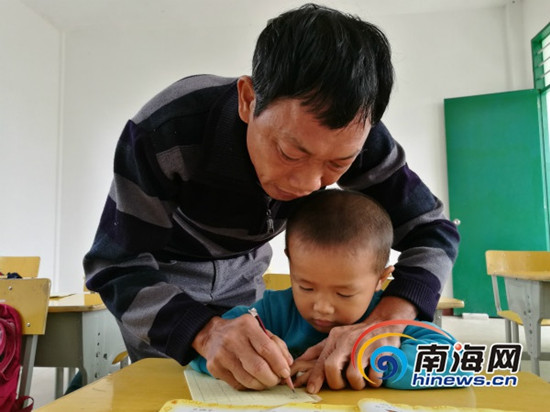 吳光明教孩子們寫字。南海網(wǎng)記者 高鵬 攝