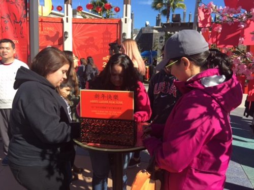 各個(gè)族裔在許愿樹下寫新年愿望。(美國《世界日?qǐng)?bào)》/張宏 攝)