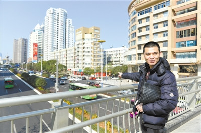 在新城天橋上，童洪建對(duì)家鄉(xiāng)巨變贊賞有加。楊冰杰 攝