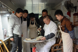 非物質(zhì)文化遺產(chǎn)項(xiàng)目代表性傳承人、省級(jí)工藝美術(shù)大師李德為學(xué)徒示范車鉆使用方法