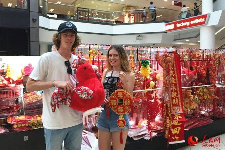 悉尼唐人街購物中心里，一家售賣中國傳統(tǒng)特色商品的店鋪顧客絡(luò)繹不絕，商鋪里里外外都掛滿了中國結(jié)、紅燈籠、春聯(lián)、年畫……正忙碌地招呼著顧客的朱太太是小店的老板，她喜氣洋洋對本報記者說：“我在唐人街開店12年了，春節(jié)前后是每年生意最好的時候?，F(xiàn)在，許多澳大利亞當(dāng)?shù)厝撕陀慰投枷矚g采購一些中國結(jié)、燈籠等裝飾品，給家里”澳大利亞姑娘格蕾絲對圖為顧客正在挑選春節(jié)裝飾品。（人民網(wǎng)記者鮑捷 攝）