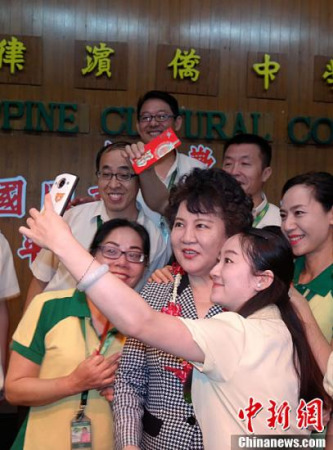 2月7日，中國國務院僑務辦公室主任裘援平率團在馬尼拉連續(xù)走訪菲律賓僑中學院和菲律賓中正學院。圖為裘援平在菲律賓僑中學院為在該校工作的29名國務院僑辦外派教師送上春節(jié)慰問金后與他們親切地玩起自拍。<a target='_blank' >中新社</a>記者 張明 攝