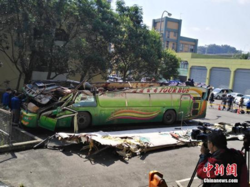 2月14日，在臺(tái)灣高速公路局北區(qū)工程處木柵工務(wù)段院內(nèi)的空地上，有關(guān)工作人員正在對(duì)游覽車(chē)的車(chē)體進(jìn)行現(xiàn)場(chǎng)勘驗(yàn)。2月13日晚，由“蝶戀花旅行社”承辦的武陵農(nóng)場(chǎng)賞櫻團(tuán)，在臺(tái)灣公路主干道發(fā)生游覽車(chē)翻車(chē)意外，目前已造成30多人罹難。<a target='_blank' >中新社</a>記者 陳林 攝