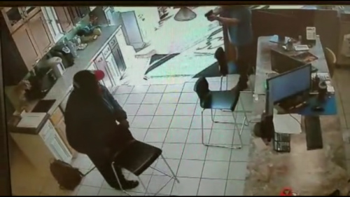 非裔嫌犯進入金麟櫥柜鬧事索財，被華裔店主譚一文拔槍嚇退。(美國《世界日報》/監(jiān)視影片截圖)