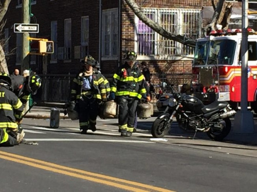 消防員正在將一個(gè)個(gè)煤氣罐從火災(zāi)現(xiàn)場(chǎng)拎出來(lái)。(美國(guó)《世界日?qǐng)?bào)》/黃伊奕 攝)