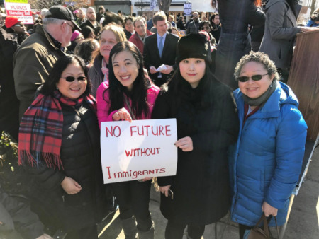 孟昭文辦公室的黃敏儀(前左二)26日手持“沒有移民就沒有未來”的標語參加游行。(美國《世界日報》取自推特)