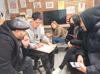 　肖勇老師（左二）帶領(lǐng)學(xué)生就近期的社會問題展開社會調(diào)查。