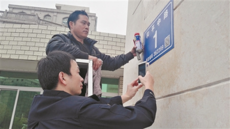 晉江市的公安民警在安裝二維碼門樓牌(蔡福仁 攝) 晉江市的公安民警在安裝二維碼門樓牌(蔡福仁 攝)