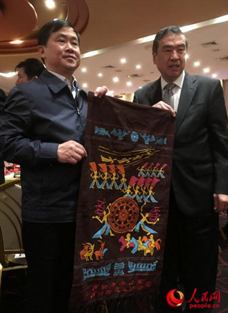 僑辦主任秦春成向廣西鄉(xiāng)親贈送家鄉(xiāng)美麗的壯錦。(謝榮鎮(zhèn)攝)
