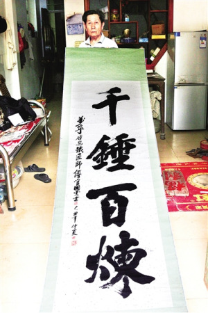 官國(guó)云展示他的書法作品。