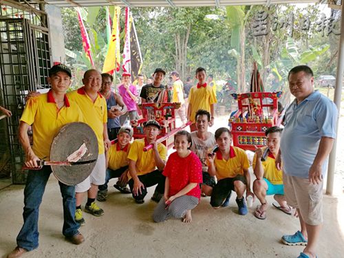 顏錦慶(右一)與現(xiàn)任爐主顏傳文(左二)在來屆爐主許友春(蹲者右三)的住家前合影。