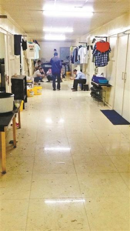 滯留工人聚集在宿舍樓道里，自2月起他們已被困了45天