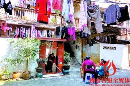 幾個(gè)市民在房子門口擺上桌子，打起了牌，優(yōu)哉游哉。/佛山日?qǐng)?bào)記者覃征鵬攝