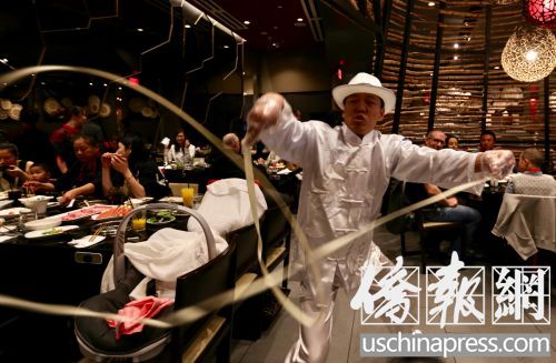 海底撈火鍋店的菜香，服務也具特色，“舞面師”在客人桌前表演。(僑報記者邱晨攝)