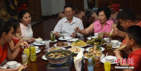 農(nóng)歷大年三十中午，柬埔寨王國華裔陳作義勛爵一家祖孫三代吃“年夜飯”。(<a target='_blank' >中新社</a>記者 黃耀輝 攝)
