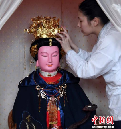 一名福州三坊七巷郎官巷天后宮道士更衣沐手、上香拜謁后為媽祖軟身神像戴上鳳冠?！∮浾邉⒖筛?攝