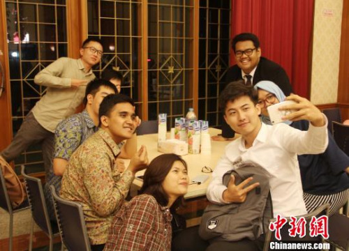 圖為兩國青年學(xué)生一起玩自拍?！×钟纻?攝