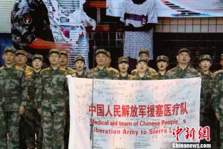 援塞醫(yī)療隊(duì)員展示隊(duì)旗?！±瞵?攝