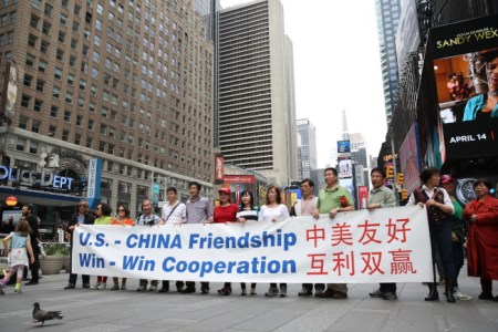 華裔民眾在時報廣場舉標語支持特朗普，認為他有助美中友好。(美國《世界日報》/洪群超 攝)