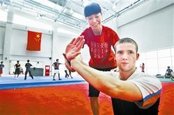 天津理工大學(xué)武術(shù)隊(duì)教練徐彩桐指導(dǎo)柯蒂斯武術(shù)招式。(圖片來(lái)源：天津《今晚報(bào)》)