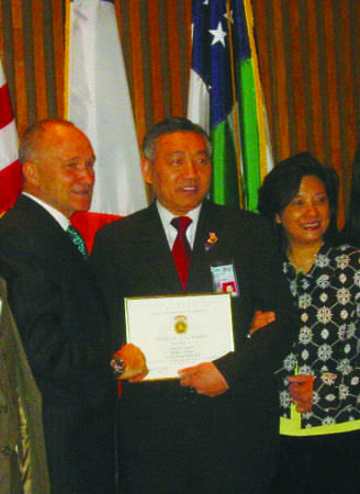 前警察總局長(zhǎng)凱利向方子源頒獎(jiǎng)，旁為方太廖巧珍。（美國(guó)《僑報(bào)》）