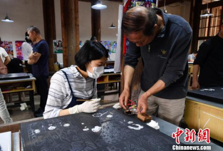 圖為漆藝?yán)蠋熤笇?dǎo)學(xué)生?！蚊?攝